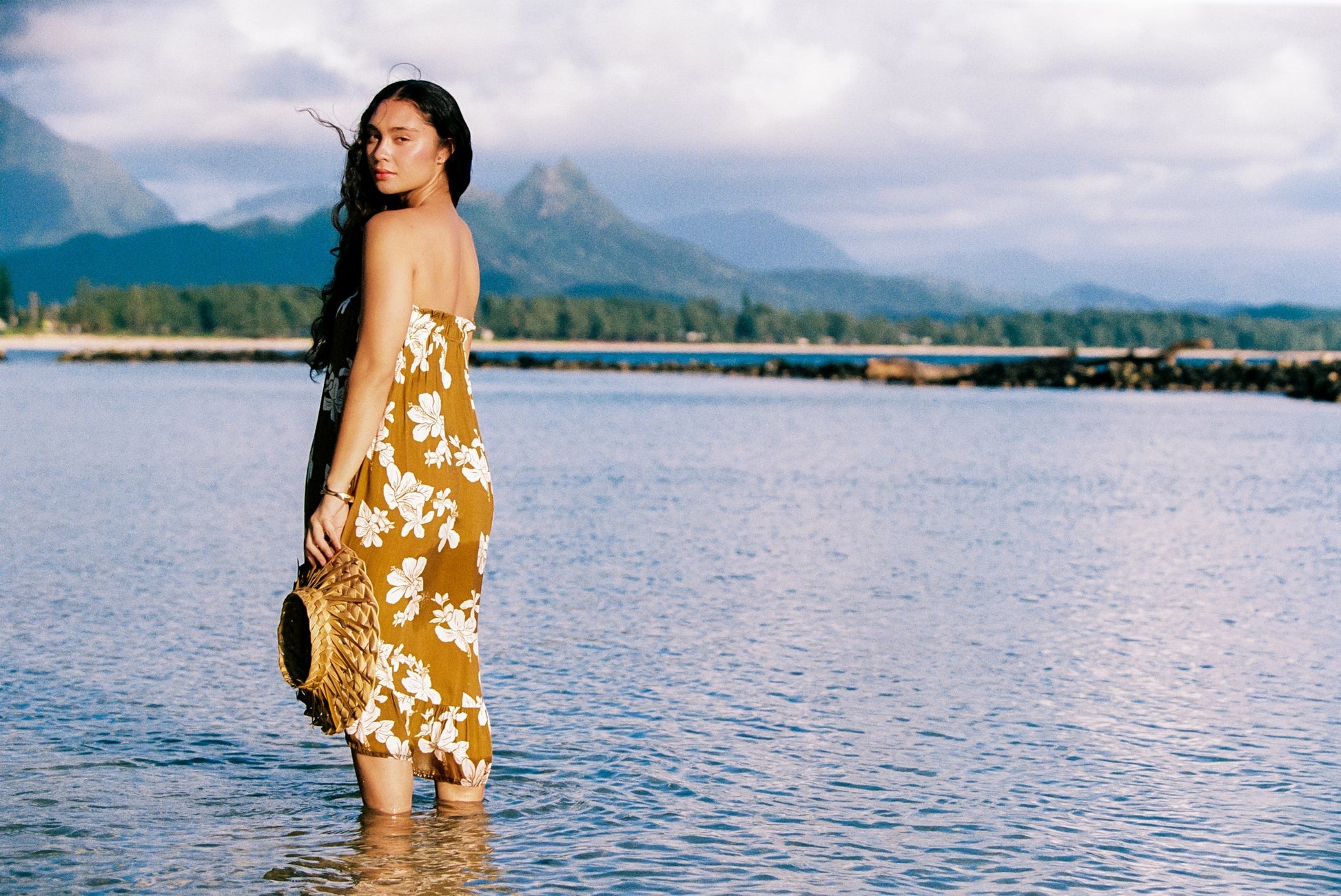 Guava Jammies Mahealani Midi Dress in mustard yellow with white floral print, strapless design, and high-low hem.
