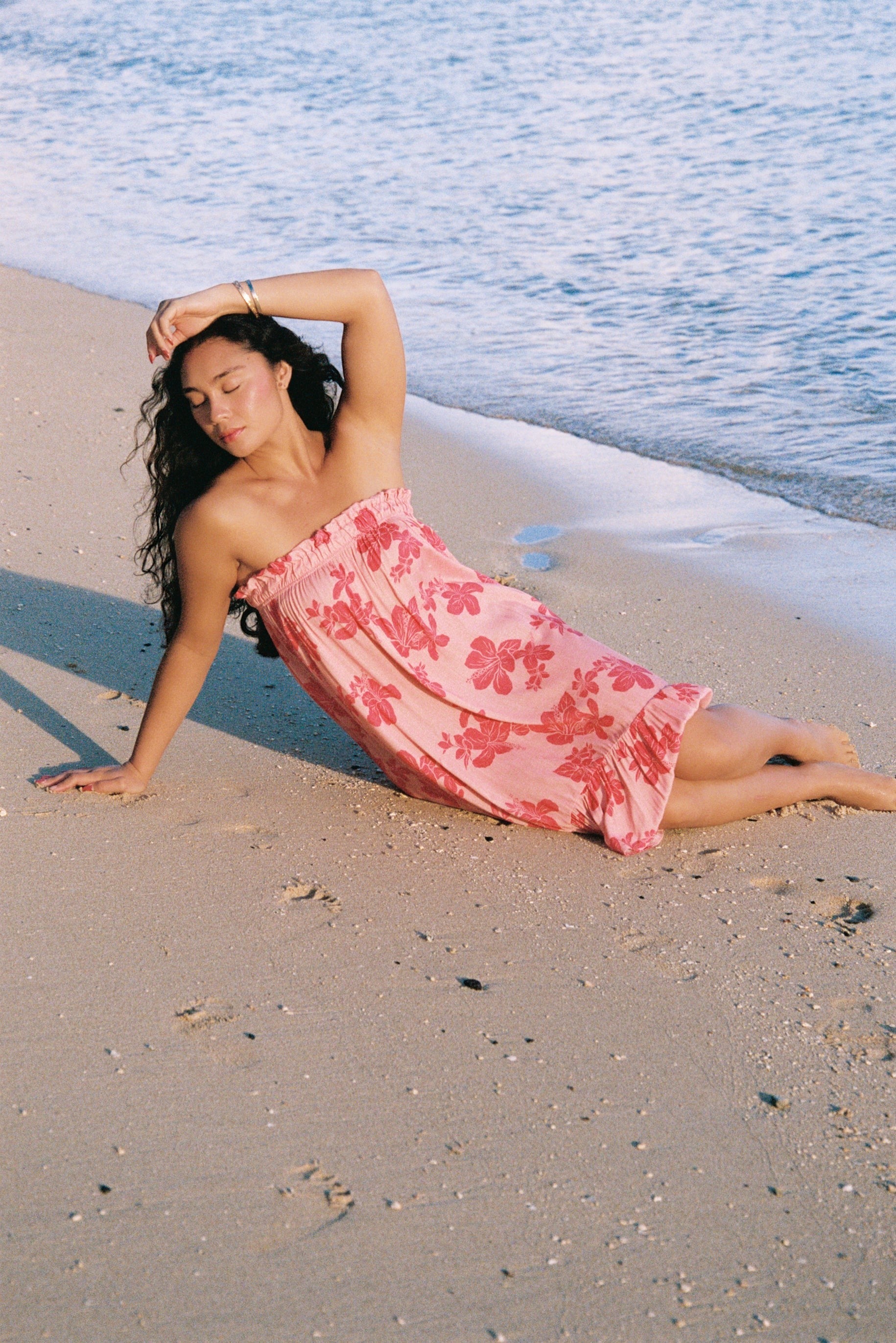 Guava Jammies Mahealani Midi Dress in pink with red floral print. Strapless, elastic top, high-low hem.