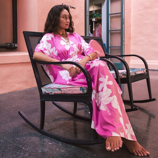 Guava Jammies Poema Island Gown in bright pink with white hibiscus floral print. Flowy, long-sleeved, V-neck, adjustable waist, waterfall back.
